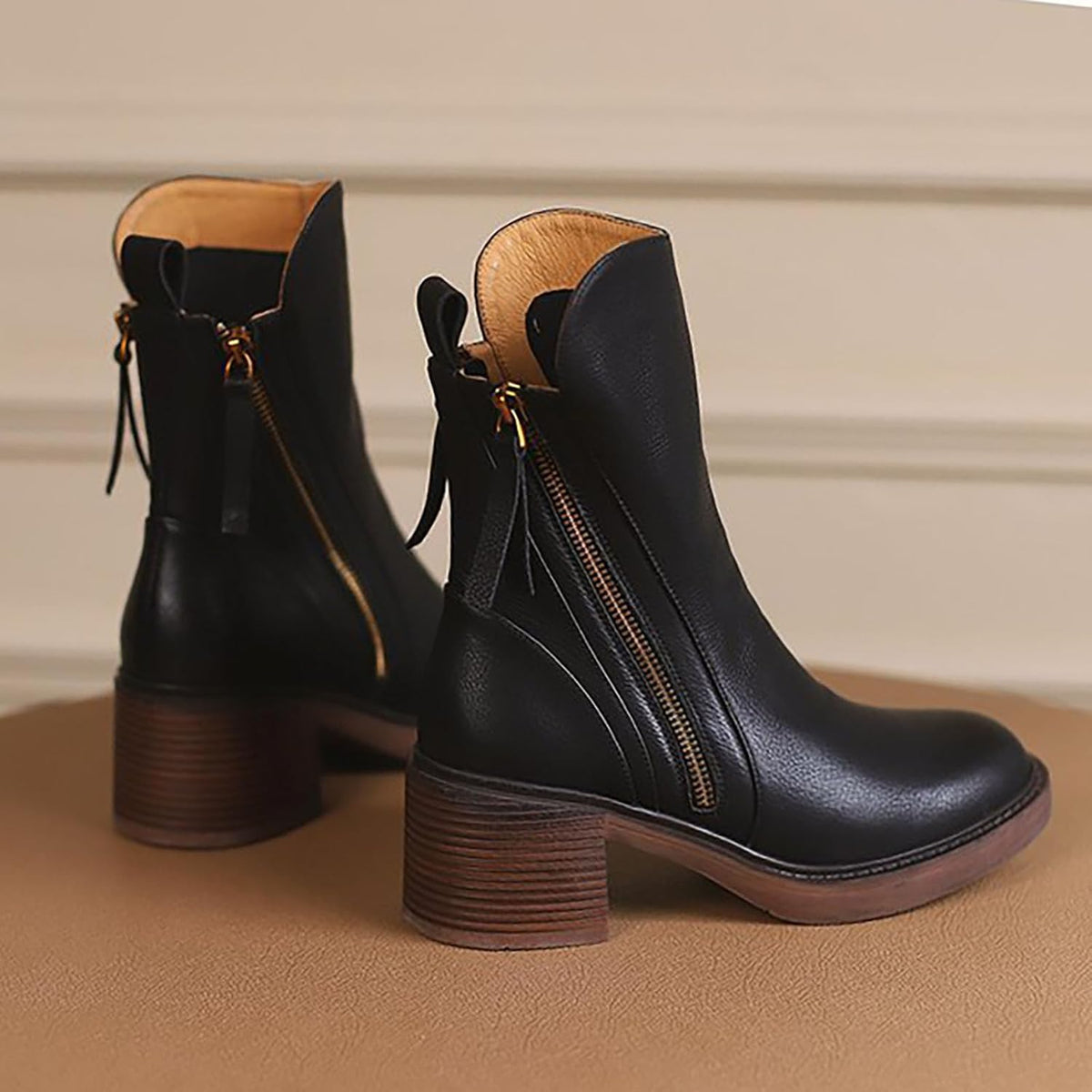 Rear view of Edith black ankle boots showing the side zips with tassel pulls and stacked block heels – Black