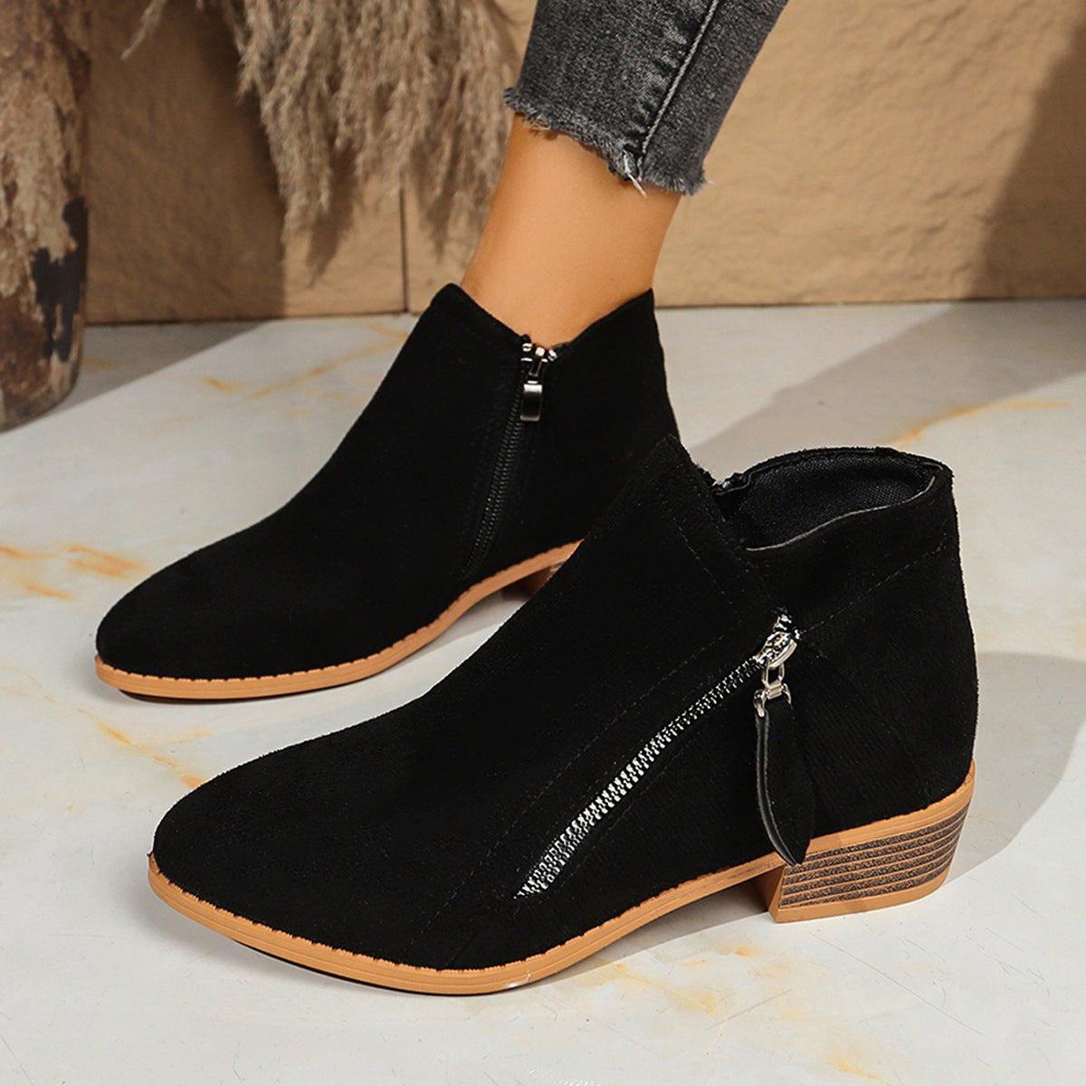 Poppy black ankle boots with diagonal zip, worn