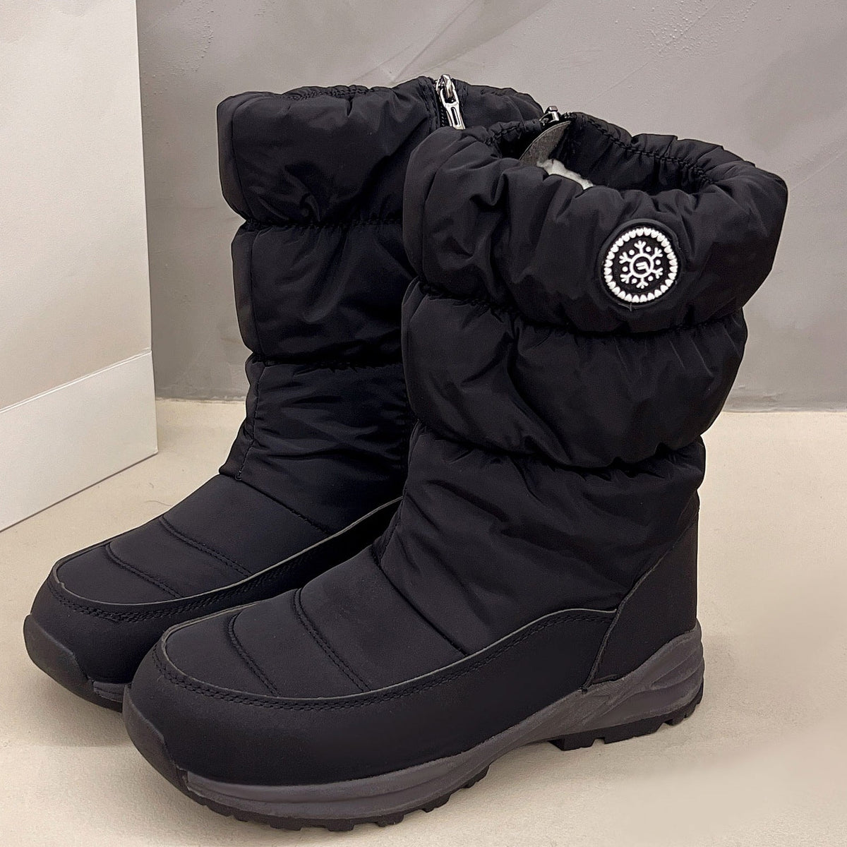 Sigrid black puffer snow boots with snowflake badge, pair