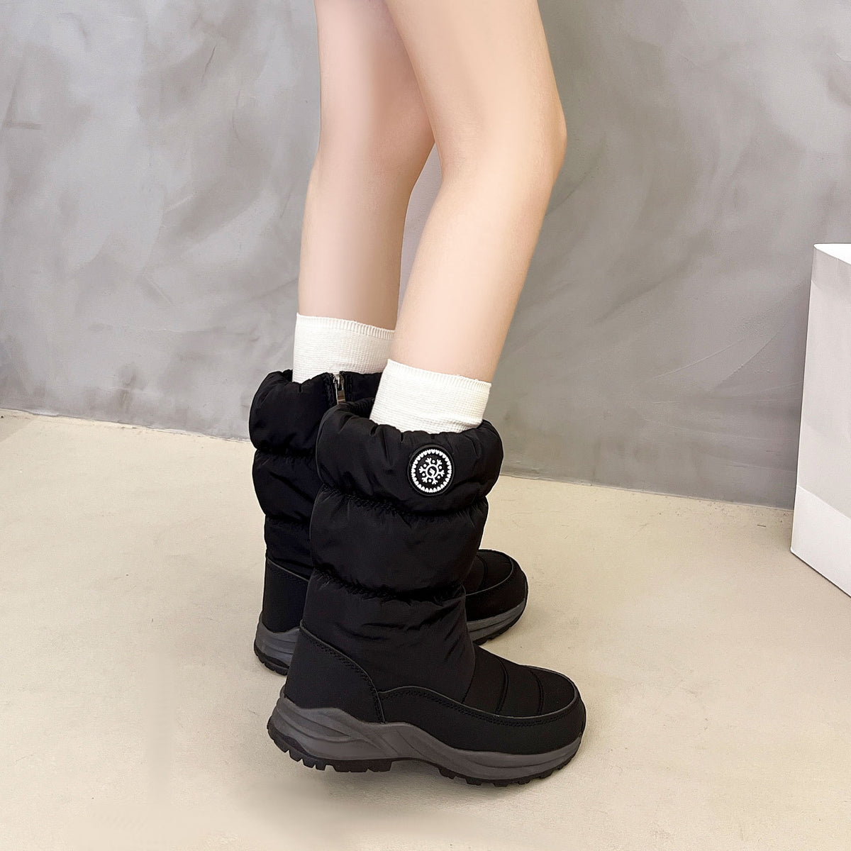 Sigrid black puffer snow boots worn with socks